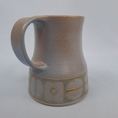 une tasse marron munie d'une anse