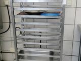 a metal rack with several trays on it in a kitchen