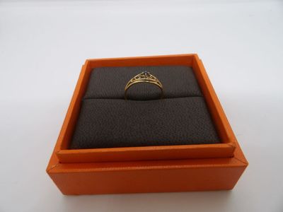 une boîte orange contenant une bague, posée sur une surface blanche