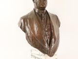 statue of a bust of a man in a suit on a marble base