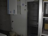 une photo d'une pièce dans laquelle se trouvent un réfrigérateur et des étagères