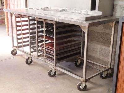 a metal cart that has many trays of food on it