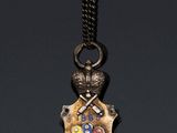 a close up of a necklace on a black surface with a black background