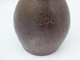 a brown vase with writing on it sitting on a table