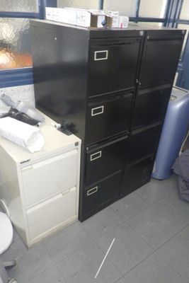 un classeur noir et des toilettes blanches dans une pièce