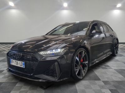 Une Audi RS4 grise est garée sur un sol à damier