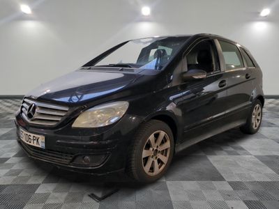une photo d'une mercedes noire de classe b garée sur un sol en damier