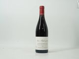 une bouteille de vin rouge posée sur une table blanche
