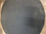 a toilet with a black seat sitting on a wooden floor