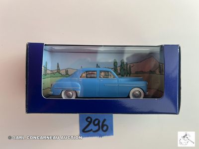 une petite voiture bleue dans une boîte bleue posée sur une surface blanche