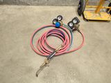 hoses and gauges are on the ground next to a fork