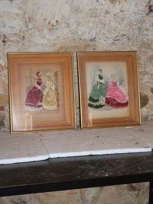 deux photos encadrées posées sur une table devant un mur en pierre