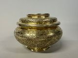 gold plated metal container with lid on a white surface