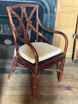 a chair with a cushion on it in front of a fire place