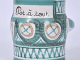 une tasse verte avec un motif sur lequel on peut lire « dot a dot »