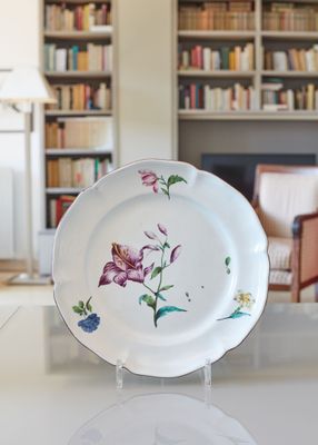 une assiette blanche ornée d'un motif floral, posée sur une table