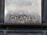 chanel logo on the side of a black leather bag