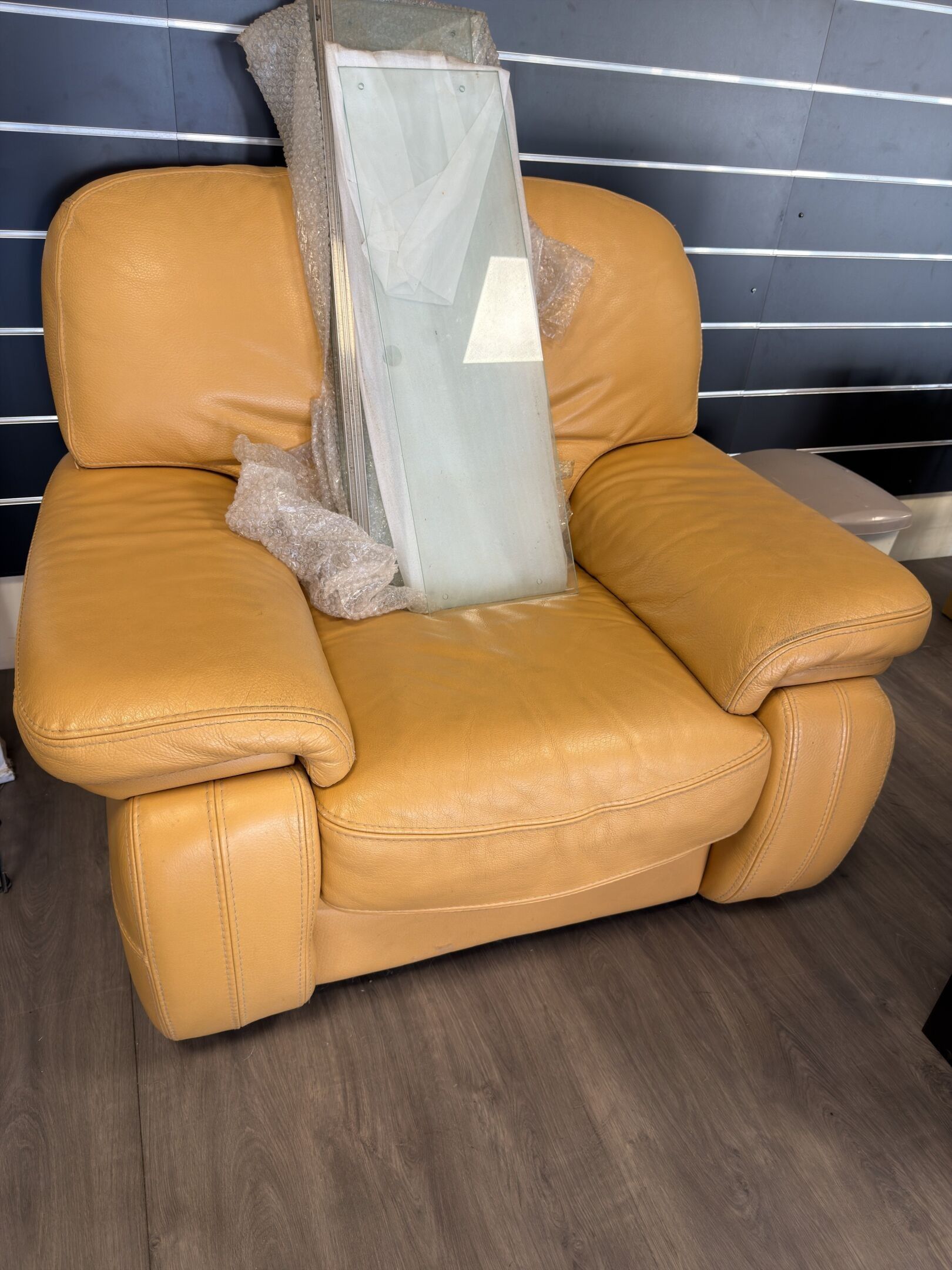 Fauteuil en cuir ocre, assise et dossier généreusement garni…