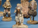 many figurines of people that are standing on a blue surface