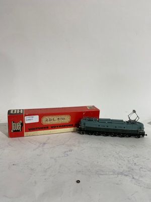 une image représentant un petit train jouet posé sur une table, à côté d'une boîte