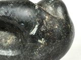 a black stone sculpture of a cat on a white surface