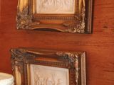 two framed pictures hanging on the wall above a cake