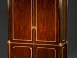 une armoire ancienne en bois à deux portes, ornée de garnitures dorées