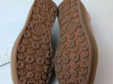 the bottom of a pair of brown shoes on a white surface