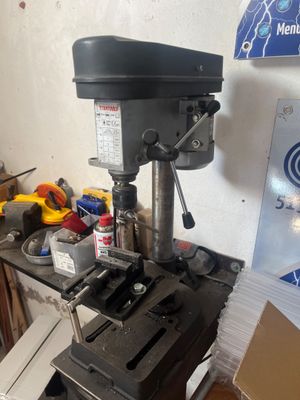 une perceuse posée sur une table dans une pièce encombrée