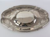 a silver plate on a white table with a mirror