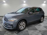 un SUV Volkswagen gris garé dans un garage au sol carrelé