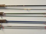 several fishing rods are lined up on a wall in a room