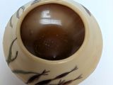 a white vase with a brown lid on a white table