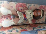 a doll that is laying on a couch next to a doll