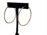 a close up of a pair of hoop earrings on a stand