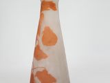 an orange and white vase sitting on a white surface