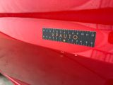a close up of a red car with a sticker on it
