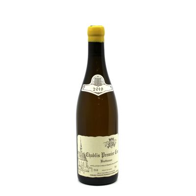 a bottle of white wine sitting on top of a white table