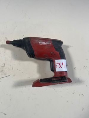 une perceuse filaire rouge posée sur une surface blanche