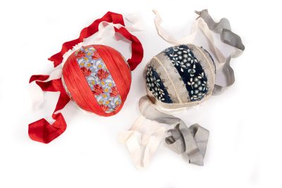 two balls of yarn and a ball of thread on a white surface
