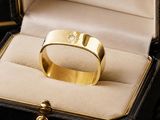 a gold ring with a diamond in it in a box