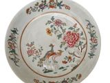 une assiette blanche décorée d'un oiseau et de fleurs
