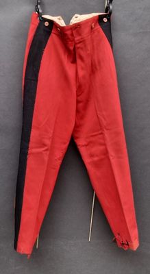un vieux pantalon rouge accroché à un mur noir