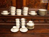 many cups and saucers sitting on a wooden table