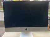 un ordinateur de bureau Apple posé sur un bureau près d'une fenêtre