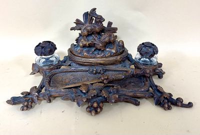 a bronze clock with birds on it on a table