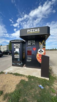 a small pizza kiosk with a large pizza on it
