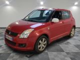 la petite voiture rouge est garée dans le garage sur un sol en damier