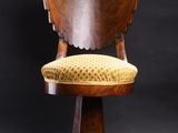 a wooden chair with yellow upholstered cushion on a black background