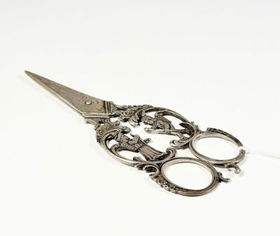 a pair of scissors sitting on top of a white surface